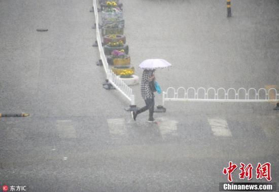 北京迎入夏后最大阵雨 民众雨中出行
