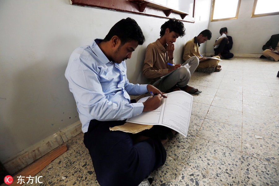 战火中的也门学生参加期末考试 坐地上答考卷