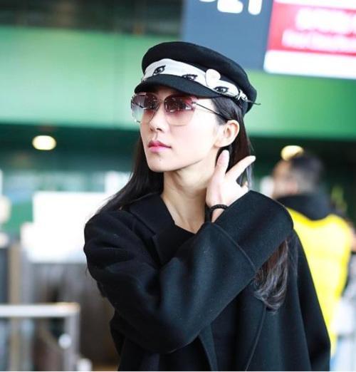 韩雪机场秀,黑色大衣开叉裙搭配小童帽,俏丽时