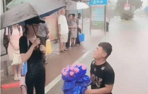 小伙雨中跪地跟女友求婚，结果后面过来的宝马车让情况发生了变化