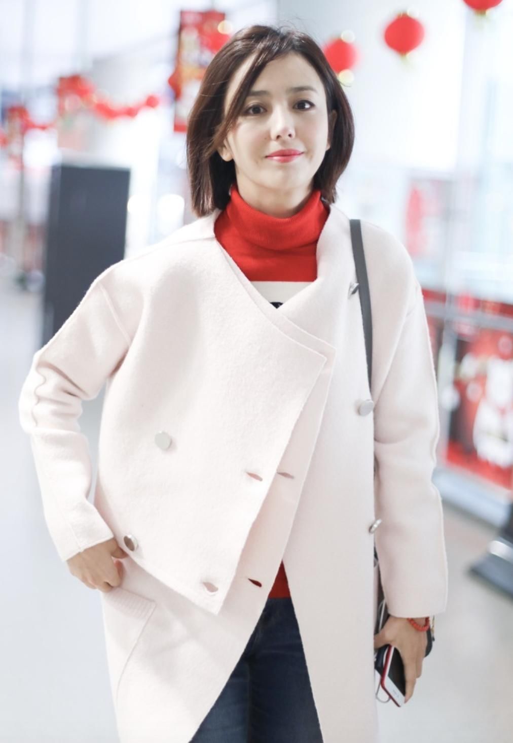 佟丽娅现身机场 一袭白色风衣内搭红色毛衣 帅