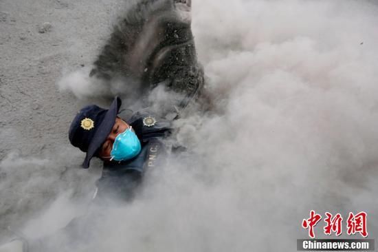 危地马拉富埃戈火山喷发 警察在火山灰中蹒跚而行