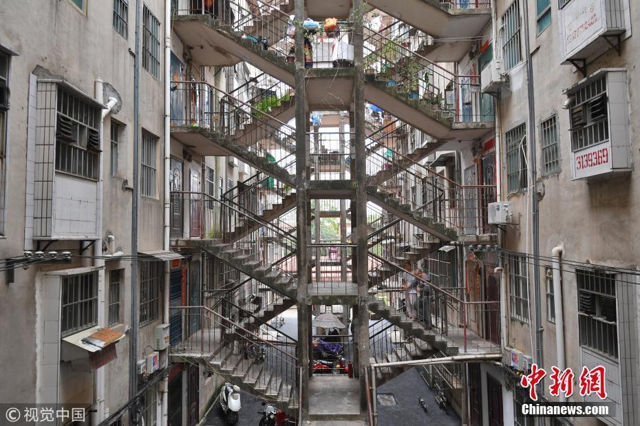 2018年10月11日，南宁，在唐山路一居民区里面现“鸳鸯楼”建筑，两栋楼共用同一个楼梯相互通行，楼层之间通过一个双向楼梯层层相连，连连相扣。图片来源：视觉中国