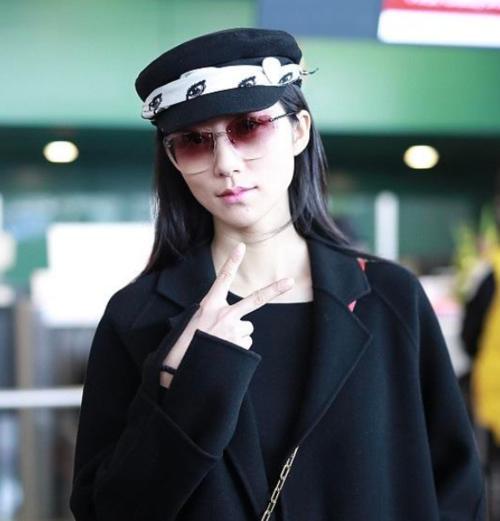 韩雪机场秀,黑色大衣开叉裙搭配小童帽,俏丽时