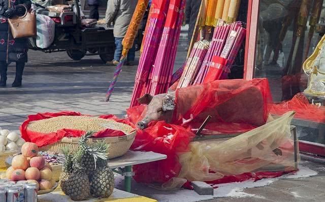 过大年，吉林北山一家佛店门前整头猪供奉，场面壮观，引人围观